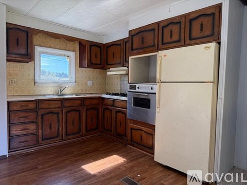 A kitchen with wooden cabinets and a white refrigerator.