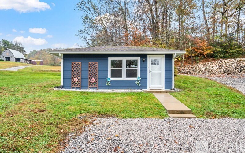 A small blue house with a white door and windows.