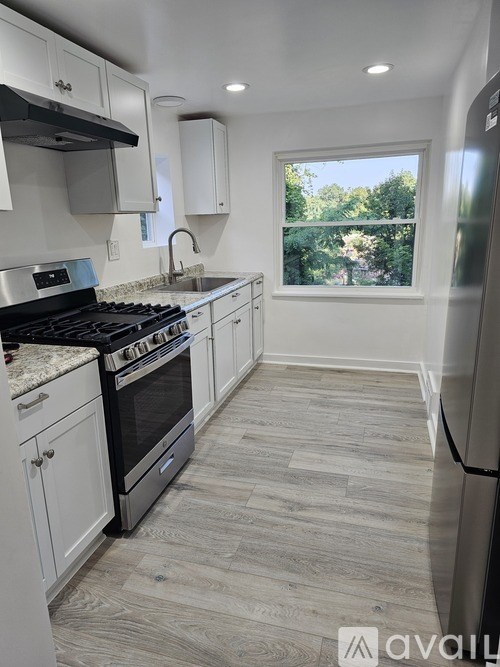 A kitchen with a black stove top oven and white cabinets.