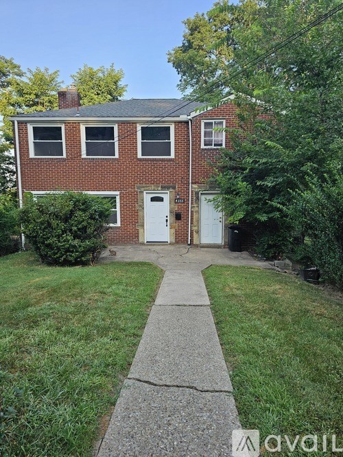 A brick house with a white door and windows.