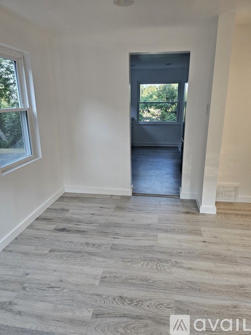 A room with a grey floor and a door leading to a balcony.