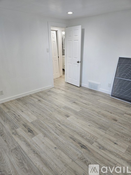A room with a wooden floor and white walls.