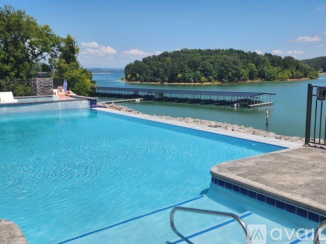 A swimming pool with a view of a lake and trees.