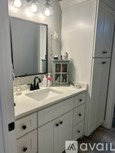 A bathroom with a sink and a mirror.