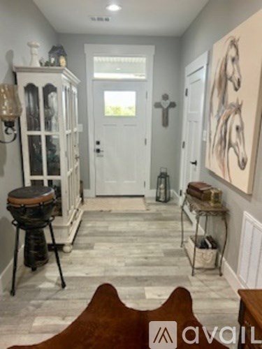 A hallway with a wooden bench and a painting of a horse on the wall.