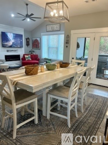 A dining room with a white table and chairs.