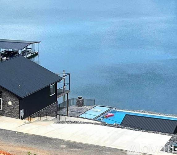 A black house with a pool in front of it.