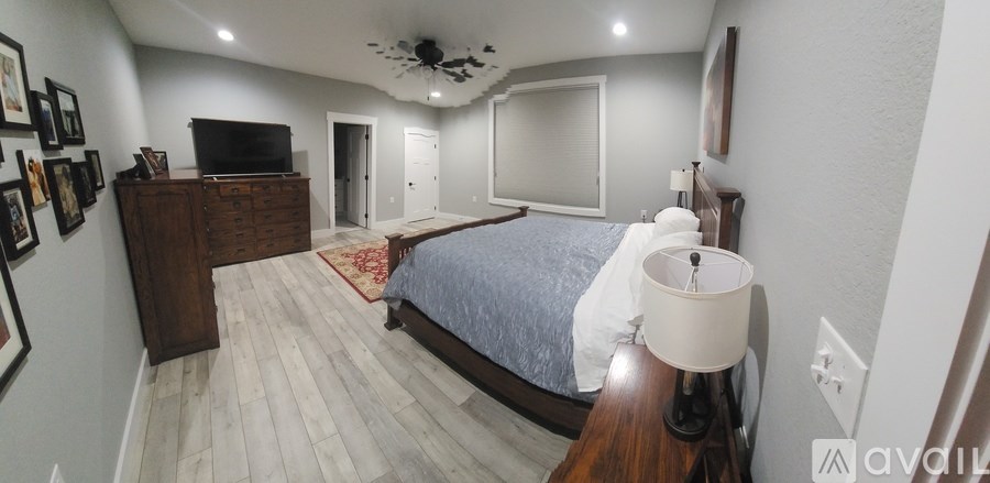 A bedroom with a bed, dresser, and television.