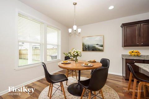 A dining room with a round table and chairs.