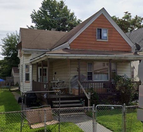 A small house with a brown roof and a white porch.