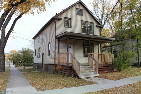 A house with a brown front porch and a brown fence.