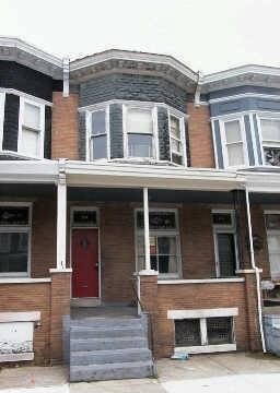 A two-story house with a red door and white trim.