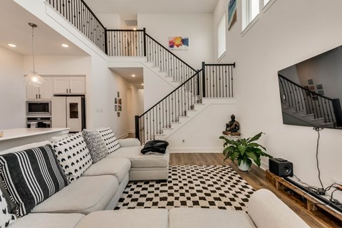 A living room with a checkered floor and a staircase.