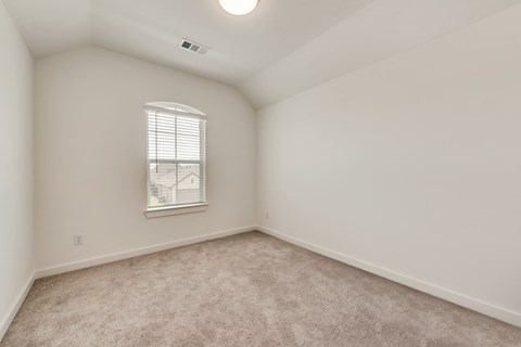 A room with a window and carpeted floor.