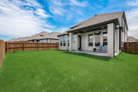A house with a green lawn in front of it.