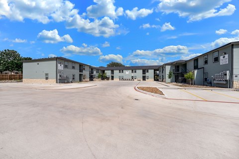 A parking lot with several buildings in the background.