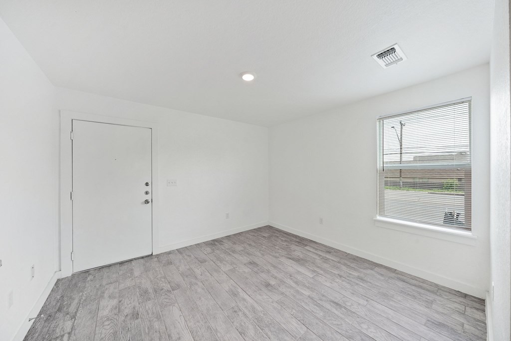 A room with a white door and a window with blinds.