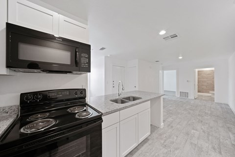 A modern kitchen with a black stove and microwave.
