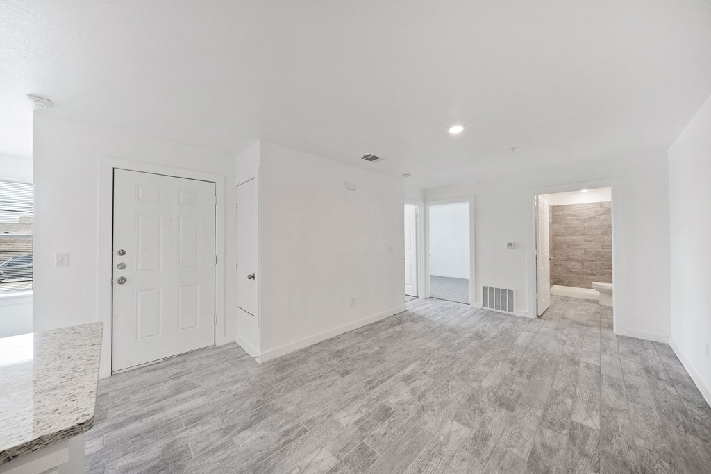 A spacious room with a marble countertop and grey flooring.