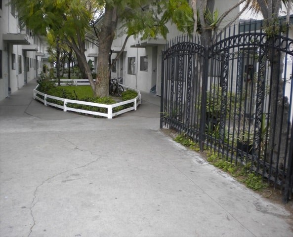 A black iron gate blocks the entrance to a courtyard.
