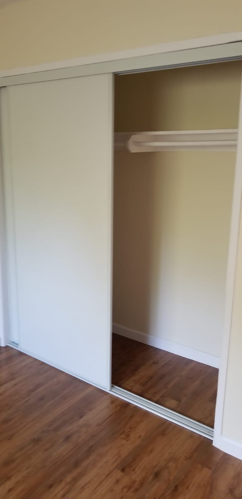A white closet with a shelf and a mirror.