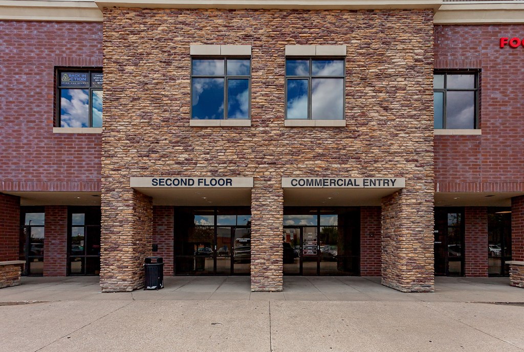 A building with a sign that says "Second Floor Commercial Entry.".