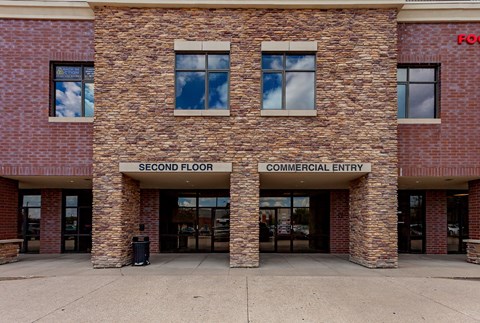 A building with a sign that says "Second Floor Commercial Entry.".