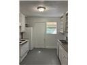 A kitchen with white cabinets and a white door.