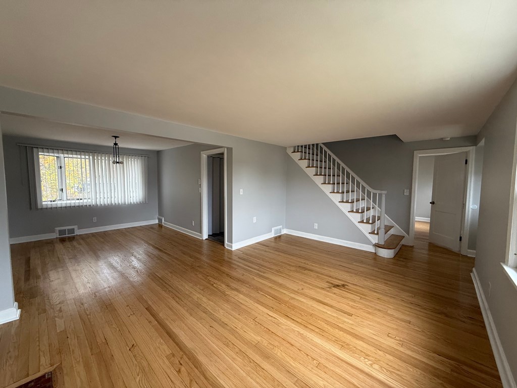 A room with wooden floors and a staircase.