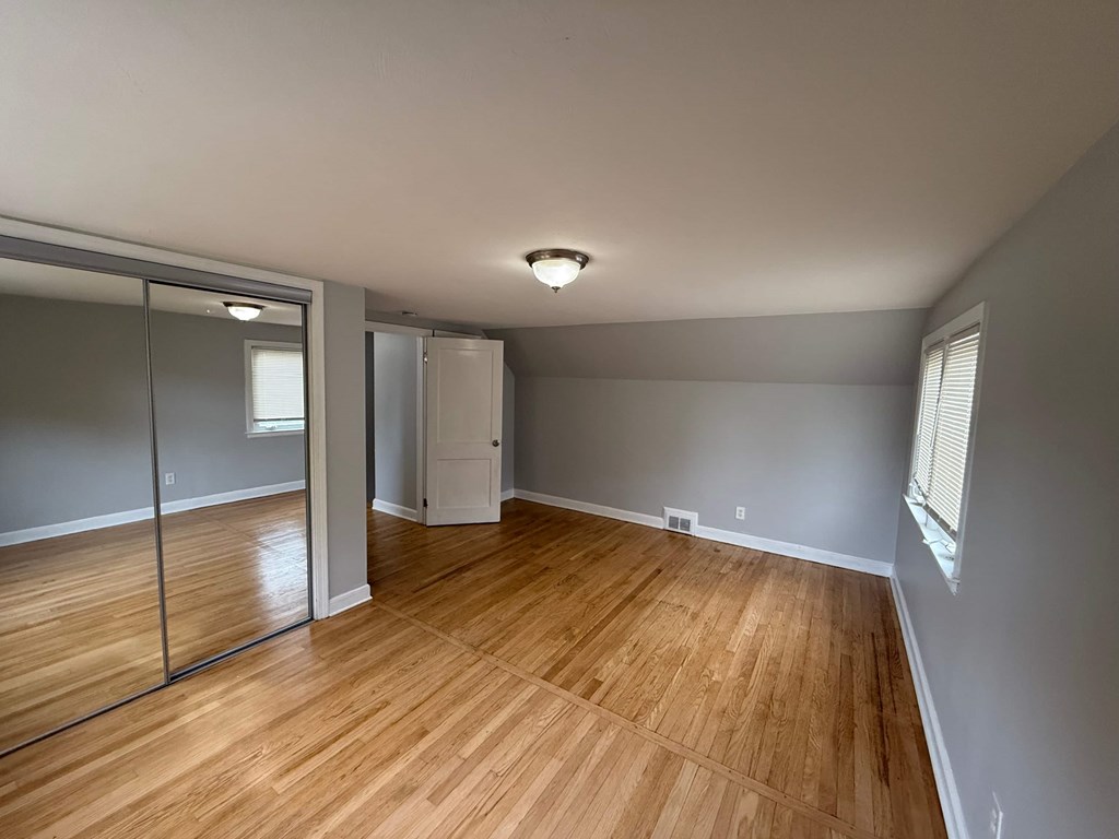 A room with wooden flooring and a sliding glass door.