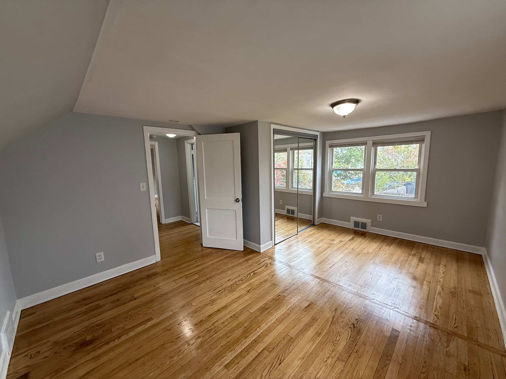 A room with wooden flooring and a white door.