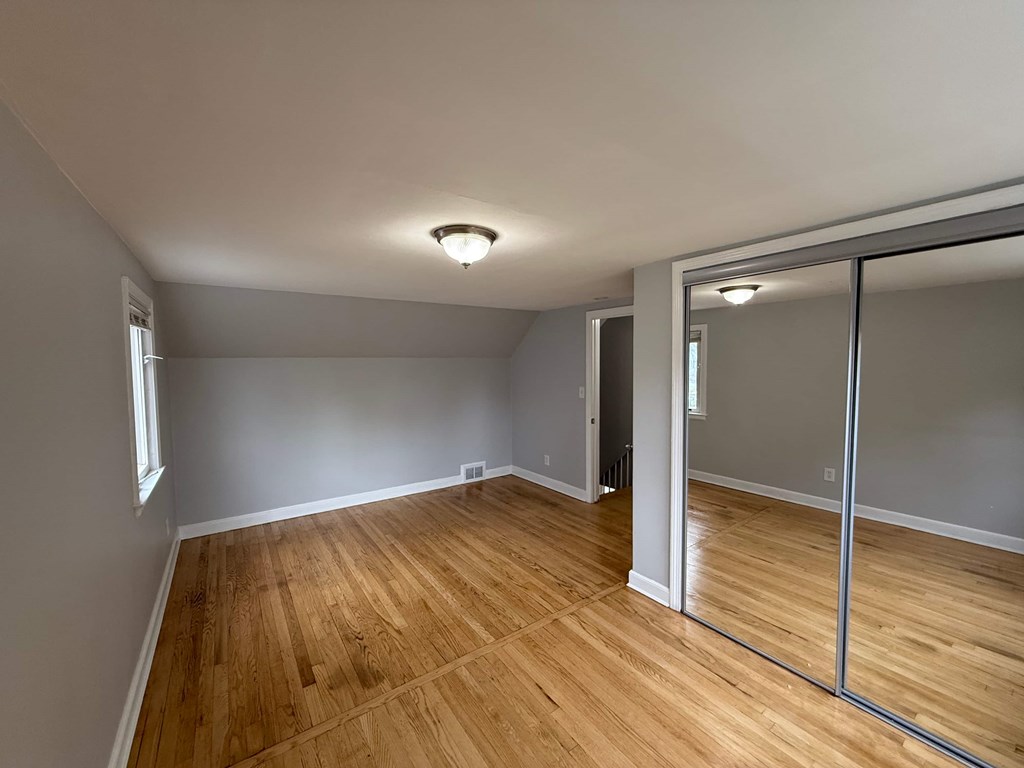 A room with wooden flooring and a sliding glass door.