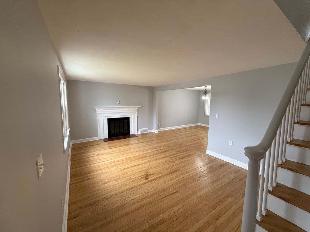 A room with a fireplace and wooden floors.