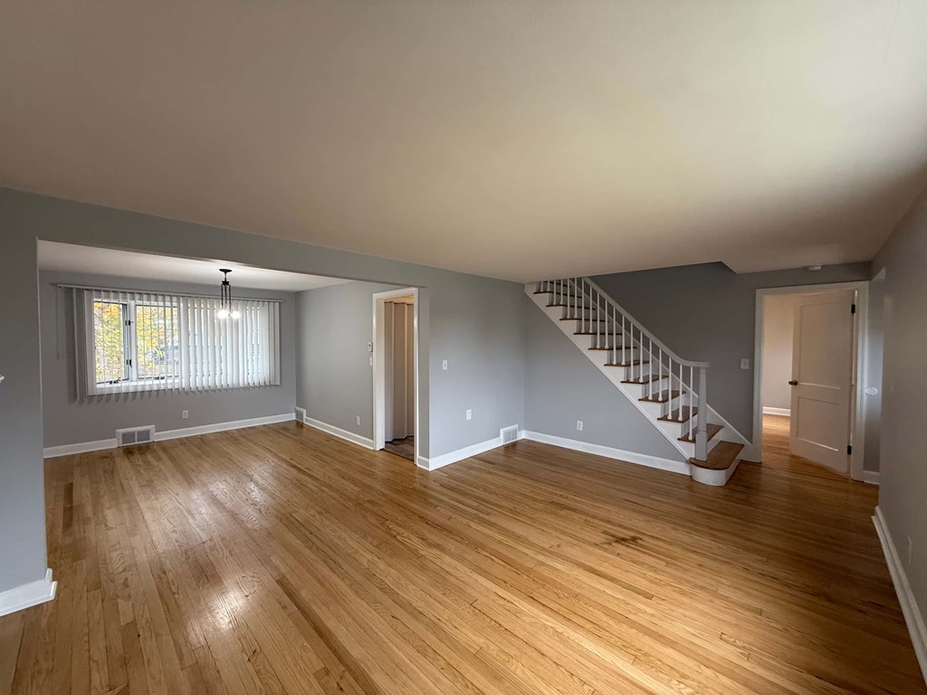 A room with wooden floors and a staircase.