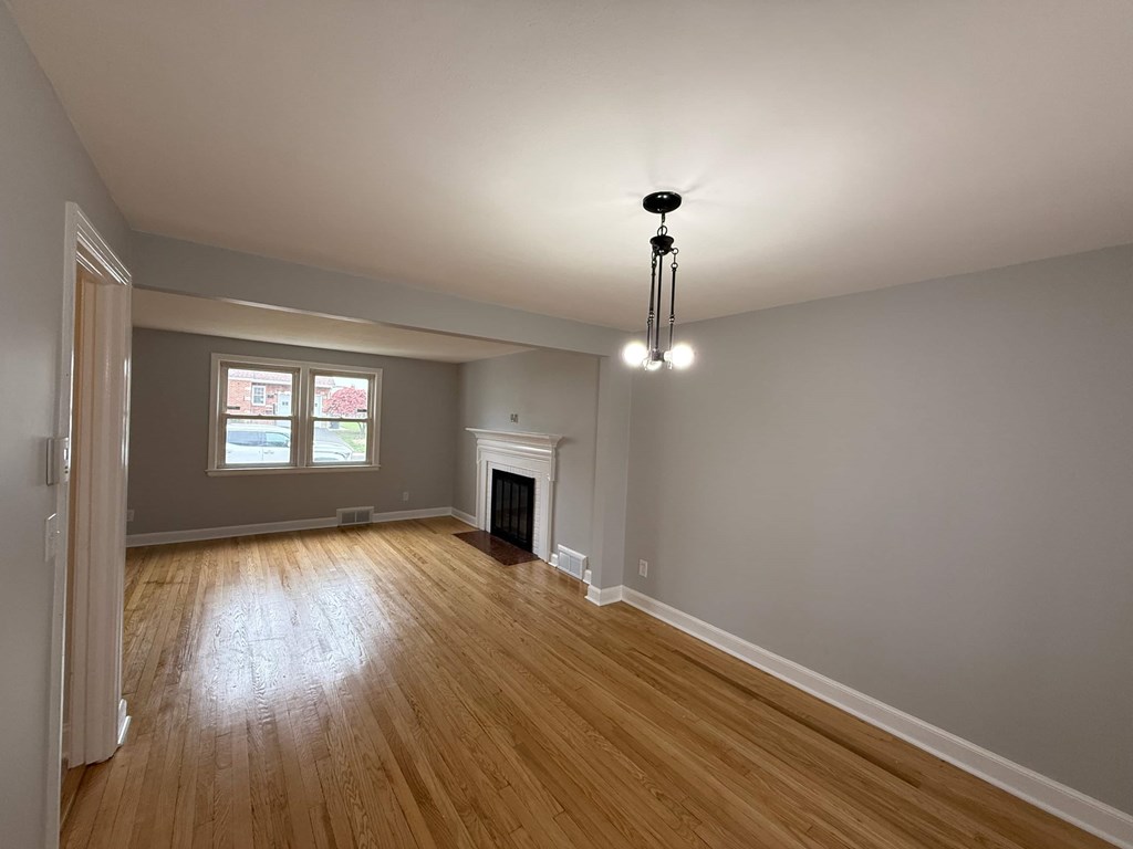 A room with wooden floors and a fireplace.