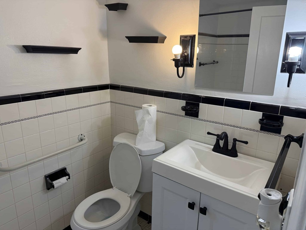 A white toilet and sink in a bathroom.