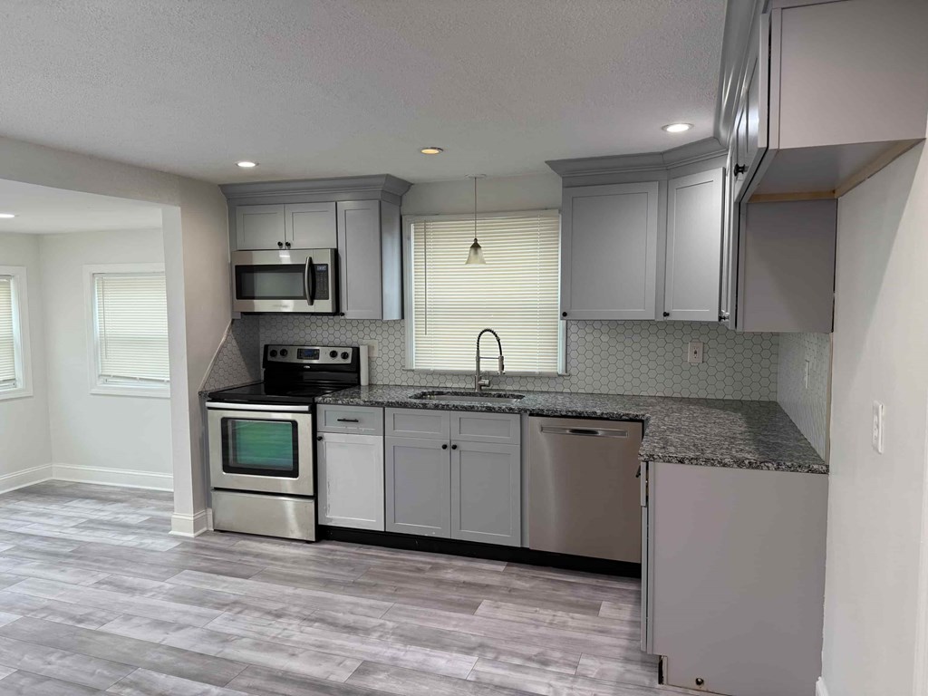 A kitchen with a stainless steel oven and microwave.