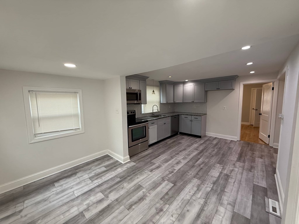 A kitchen with a grey floor and white walls.