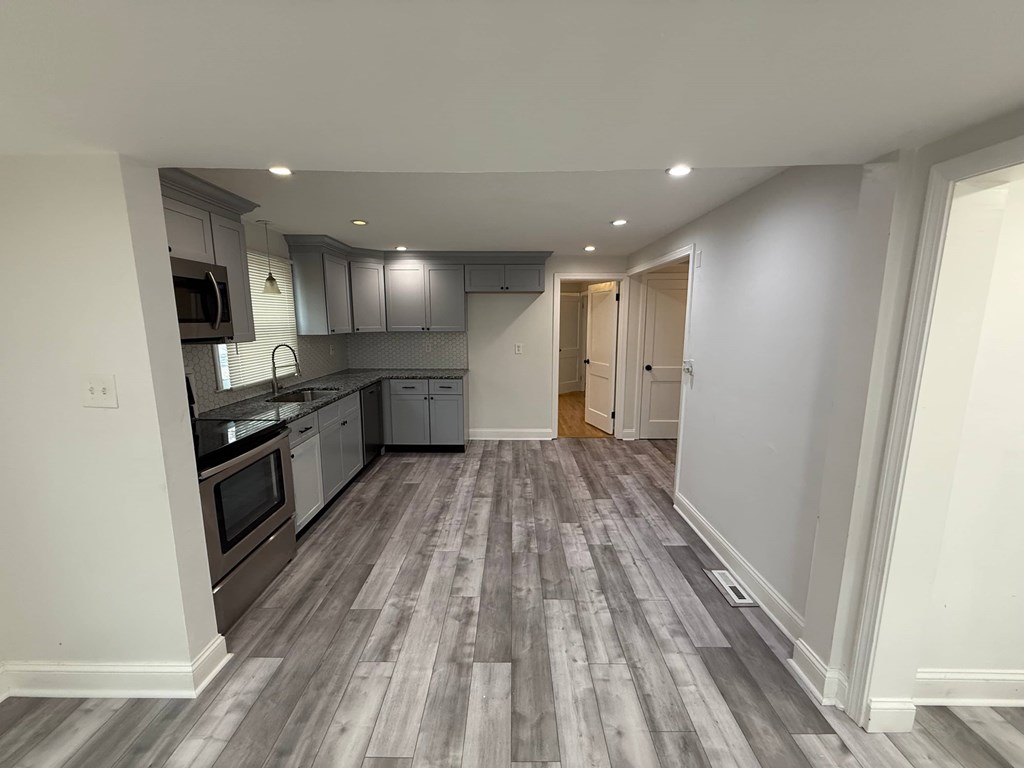 A kitchen with a grey floor and white walls.