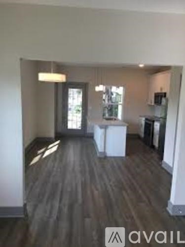 A room with wooden flooring and a white cabinet.