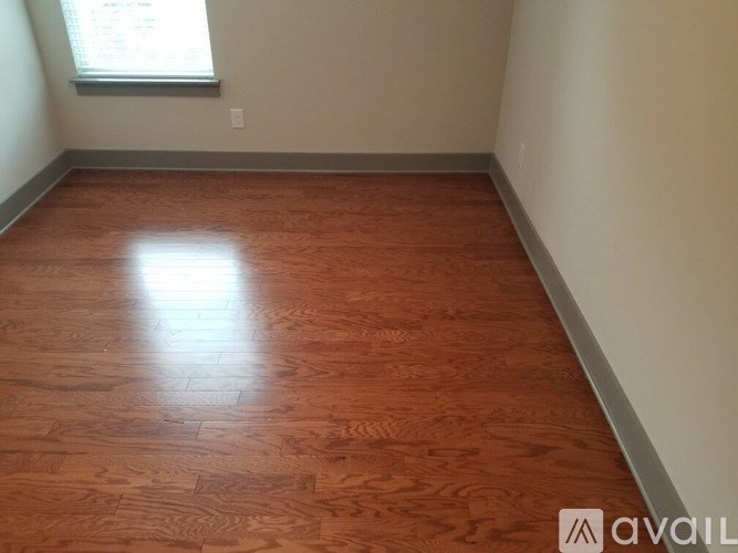 A room with wooden flooring and a window.