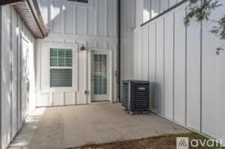 A white house with a black air conditioning unit outside.