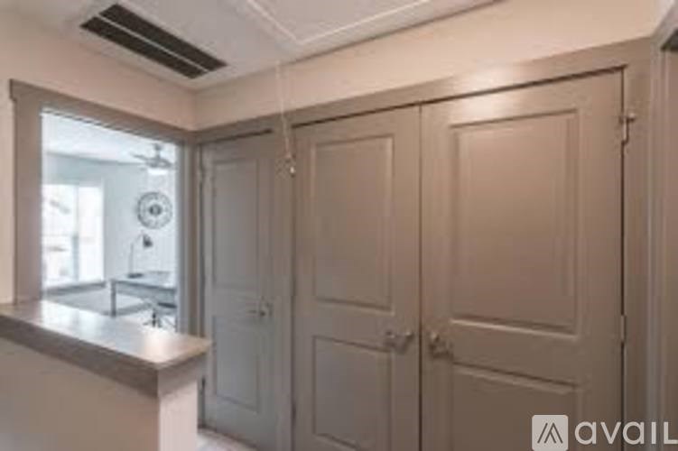 A kitchen with a window, sink, and cabinets.