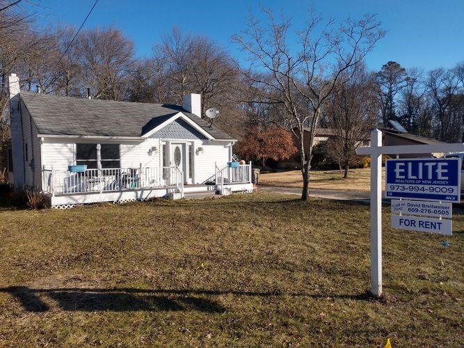 A white house with a sign that says "ELITE" in front of it.