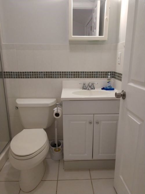 A white toilet sits next to a sink in a small bathroom.