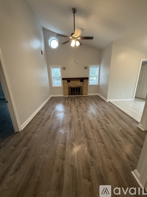 A room with wooden flooring and a window with blinds.