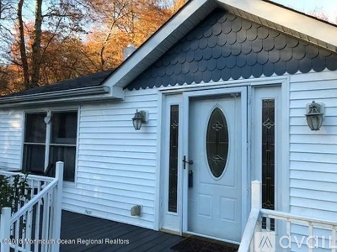 A red washing machine is stacked on top of a black one in a cabinet.