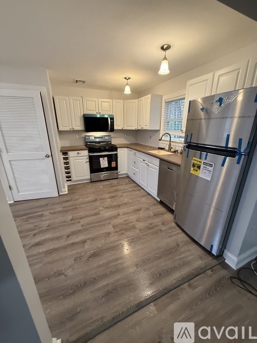 A small white house with a black roof and a porch.