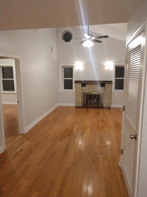 A room with a fireplace and wood floors.