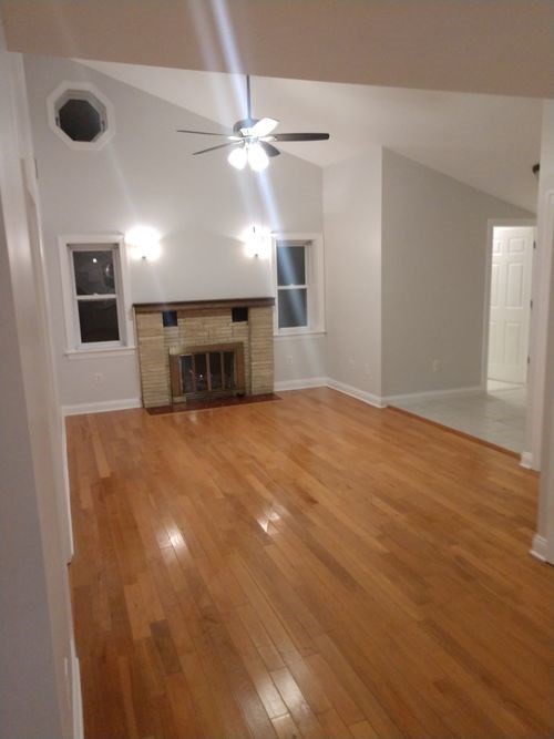 A room with a fireplace and a ceiling fan.